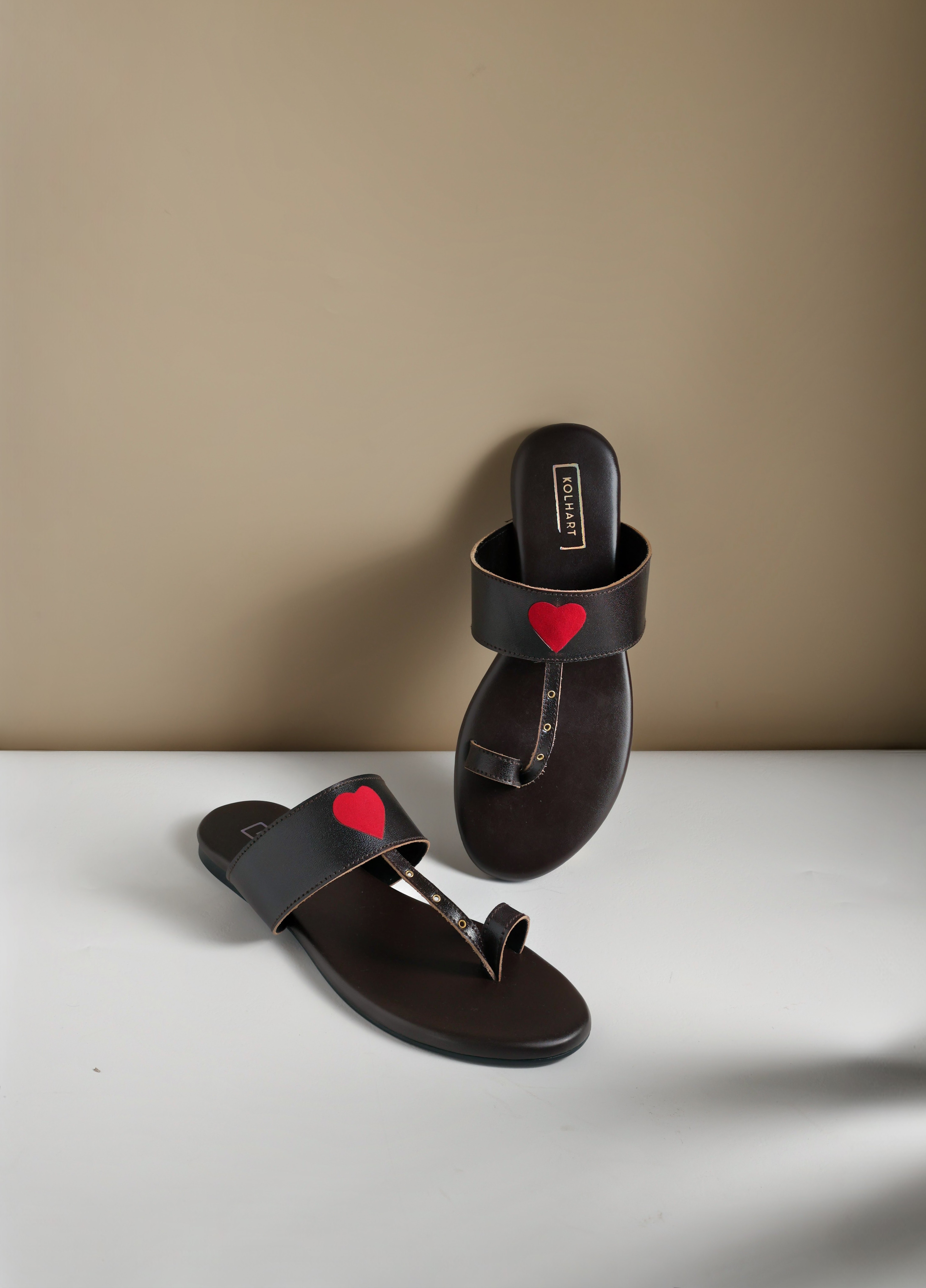 Pair of stylish black sandals with red heart detail on straps